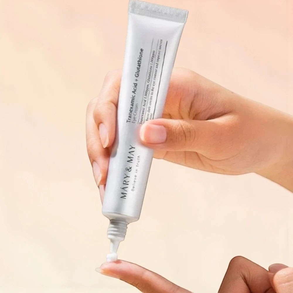 Skin TOGO Mary&May Tranexamic Acid + Glutathione eye cream being squeezed from a white tube onto a fingertip.