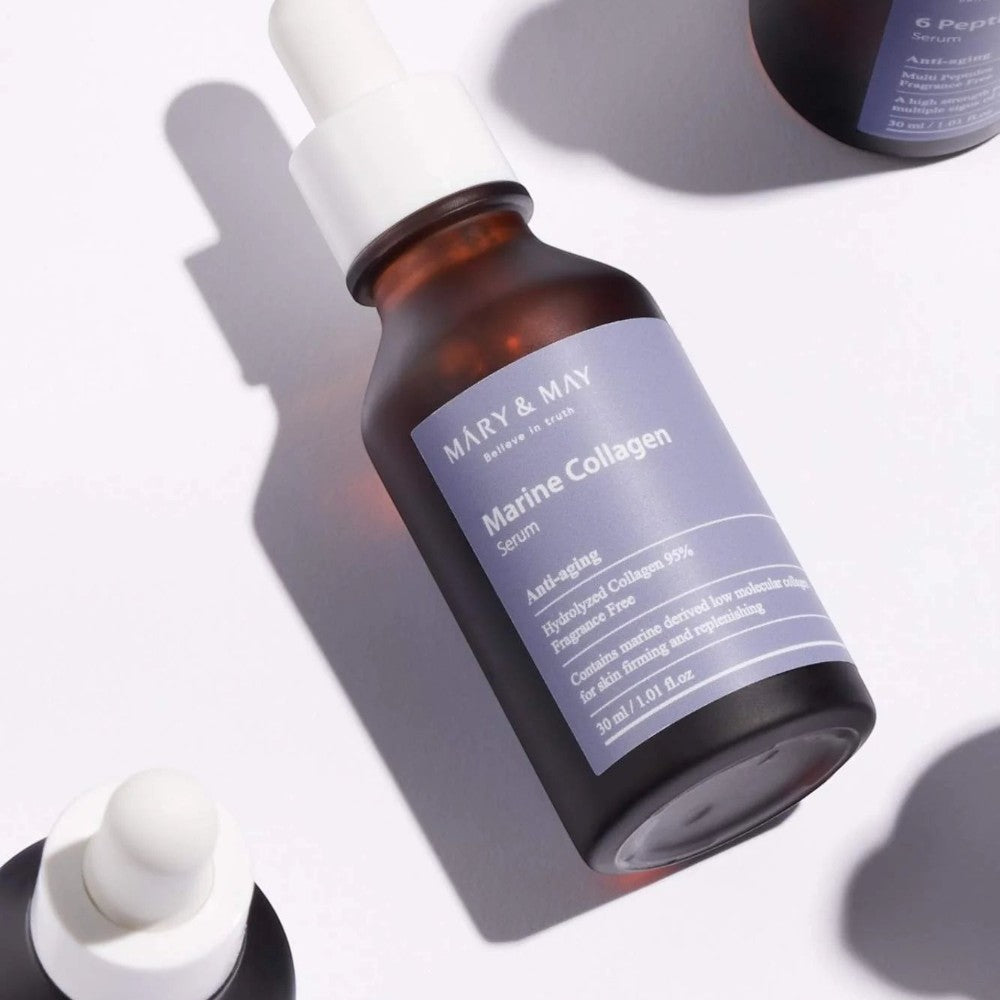 Skin TOGO Mary & May 6 Peptide Complex anti-aging serum in a brown glass dropper bottle on a white surface.