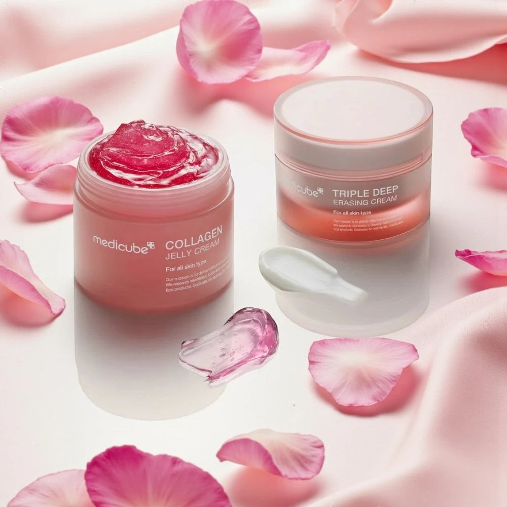 Skin TOGO Medicube Collagen Jelly Cream and Triple Deep Erasing Cream jars with pink rose petals on silk fabric.