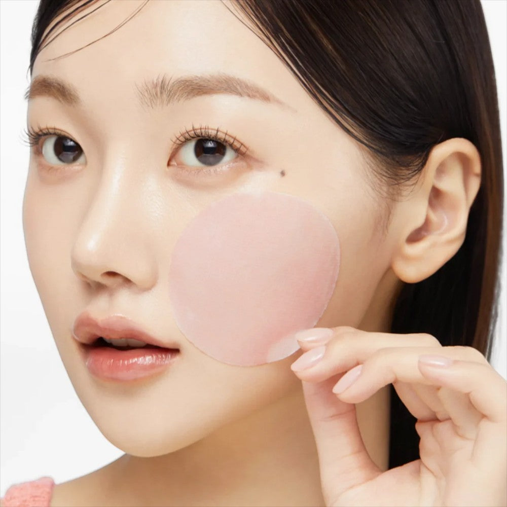 Skin TOGO model applying a pink Medicube PDRN Collagen gel toner pad to her cheek for skin hydration and firming