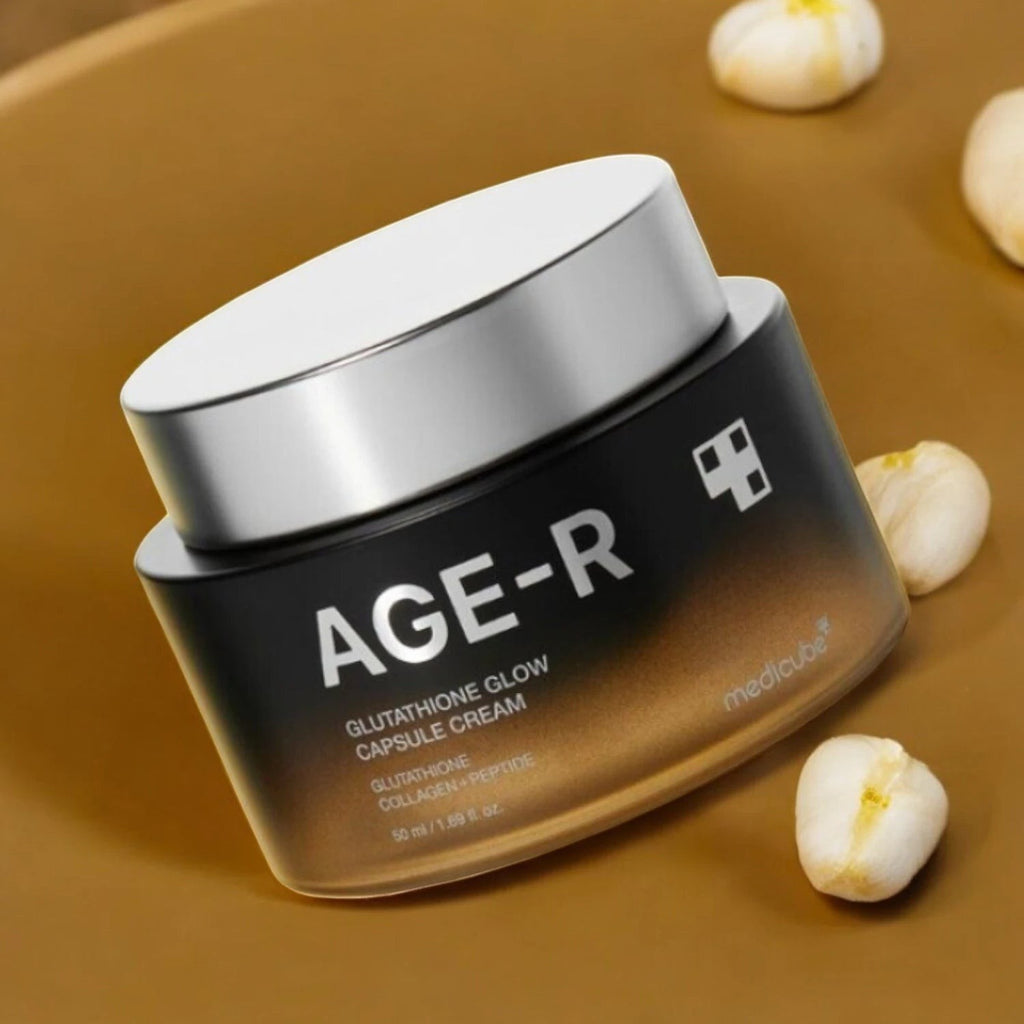 Skin TOGO Medicube AGE-R Glutathione Glow Capsule Cream in a black and gold jar on a warm brown surface.