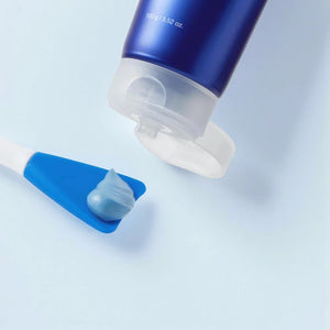 Skin TOGO Medicube Zero Pore Blackhead Mud Mask squeezed onto a blue applicator spatula against a light blue background
