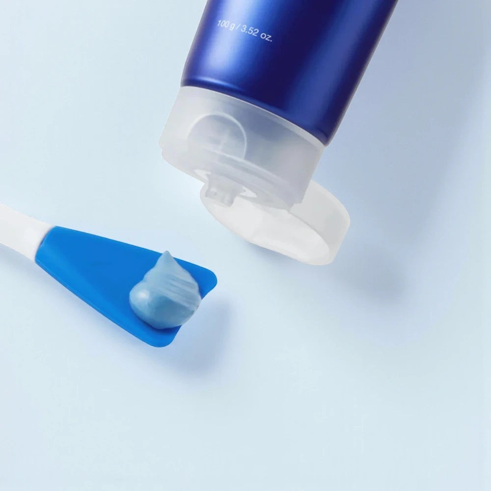 Skin TOGO Medicube Zero Pore Blackhead Mud Mask squeezed onto a blue applicator spatula against a light blue background