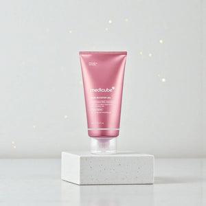 Skin TOGO Medicube PDRN Booster Gel in a pink tube on a white pedestal for skin regeneration and hydration.