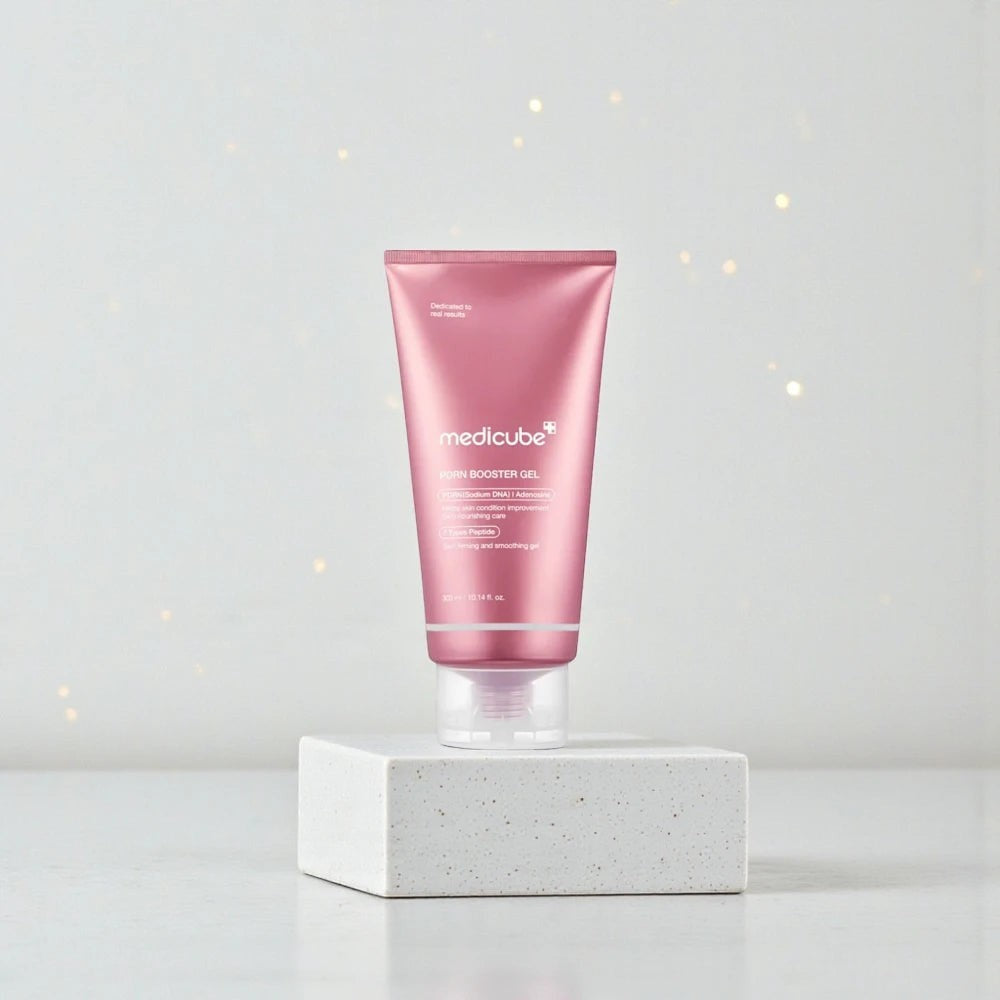 Skin TOGO Medicube PDRN Booster Gel in a pink tube on a white pedestal for skin regeneration and hydration.