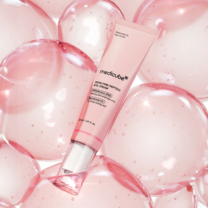 Skin TOGO Medicube PDRN Pink Peptide Eye Cream tube surrounded by translucent pink bubbles for a hydrating effect