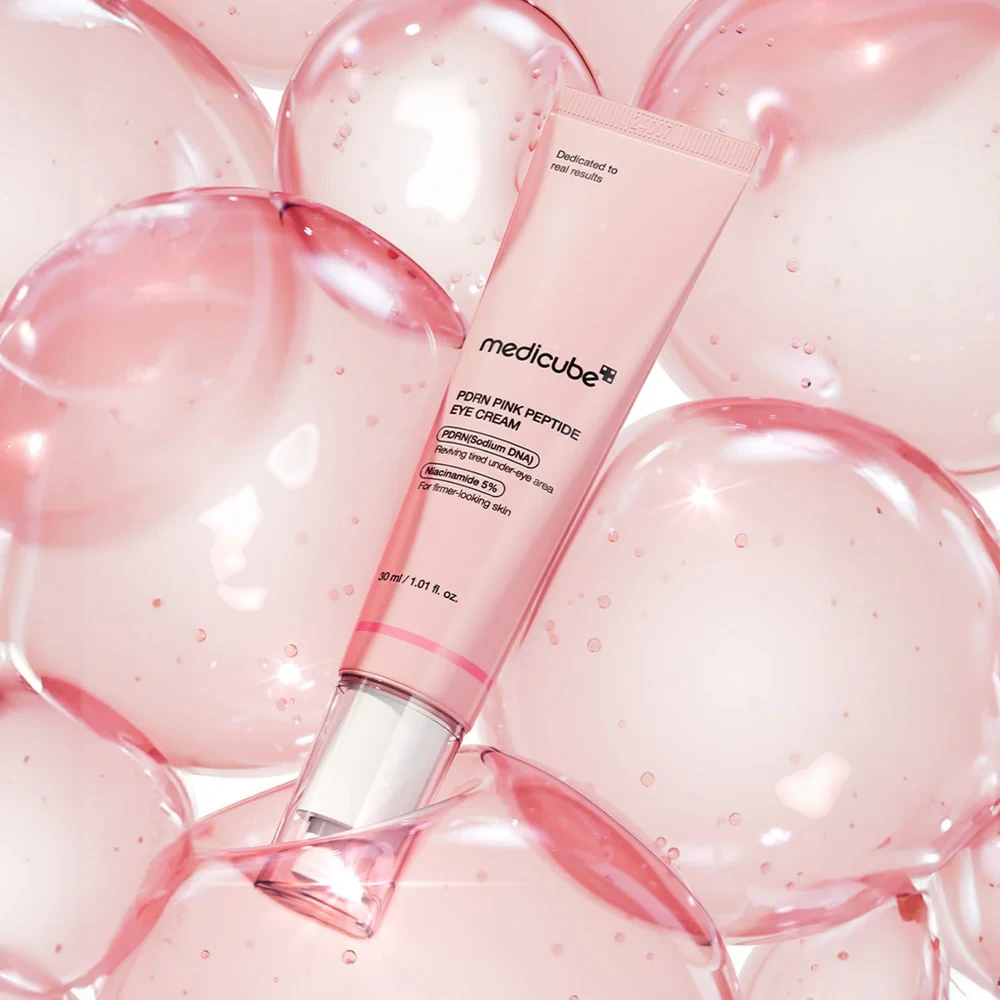 Skin TOGO Medicube PDRN Pink Peptide Eye Cream tube surrounded by translucent pink bubbles for a hydrating effect