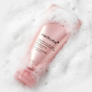 Skin TOGO Medicube PDRN Pink Glutathione Capsule Cleansing Foam in a pink tube surrounded by rich, velvety soap lather.