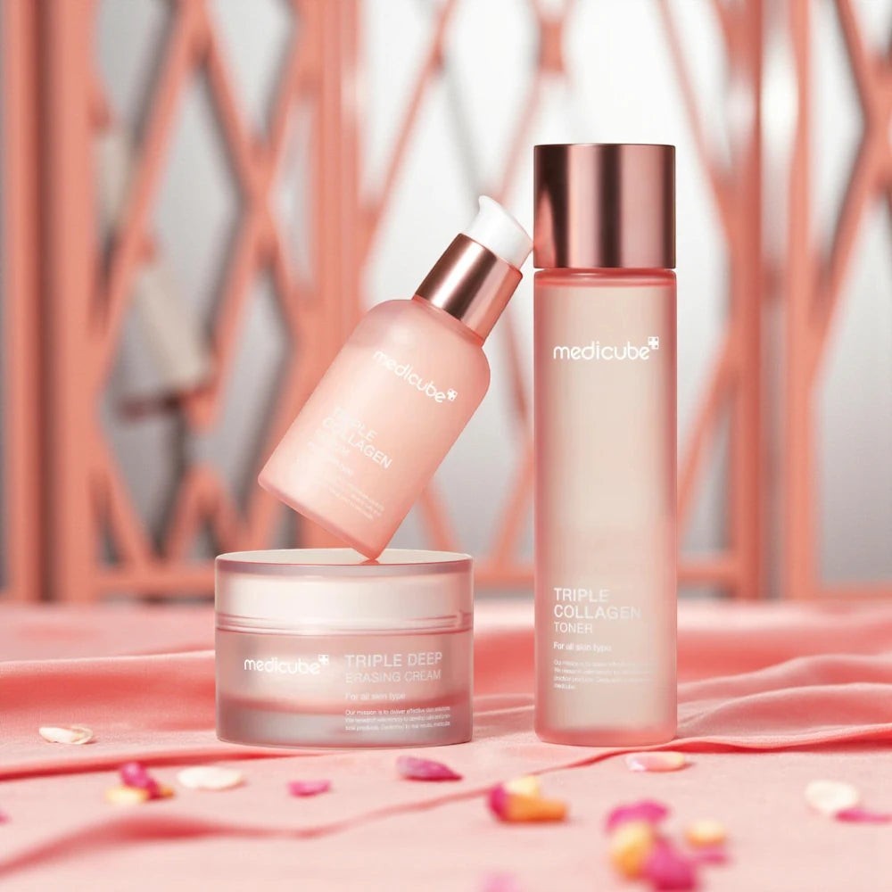 Skin TOGO Medicube Triple Collagen skincare set featuring toner, serum, and cream in pink packaging on silk fabric.