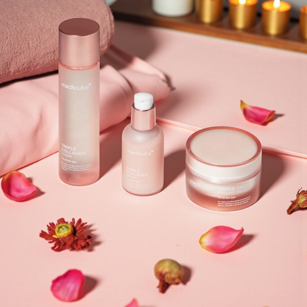 Skin TOGO Medicube Triple Collagen skincare set with toner, serum, and cream on a pink surface with flower petals.