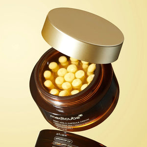 Skin TOGO Medicube Deep Vitamin C Capsule Cream in a brown jar with visible yellow vitamin capsules and gold lid.