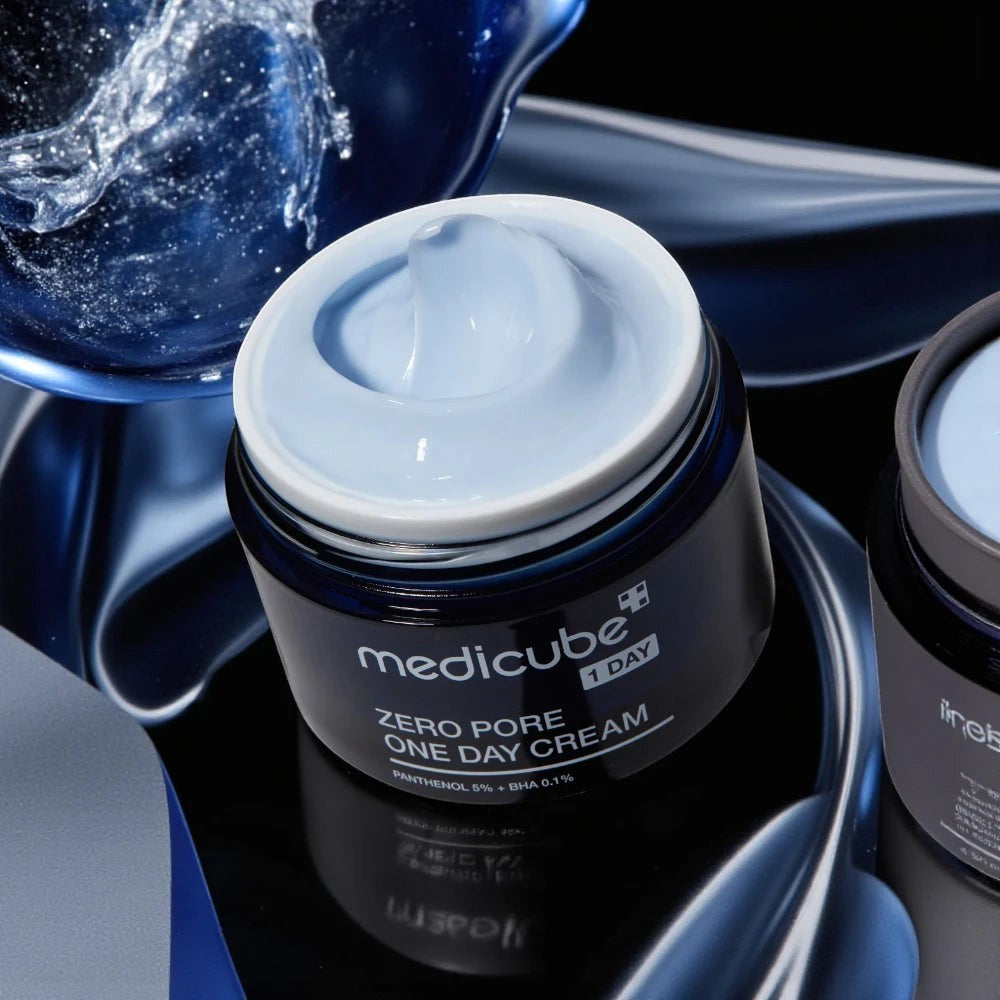 Skin TOGO Medicube Zero Pore One-day Cream in a dark blue jar with light blue gel-cream texture on a reflective base