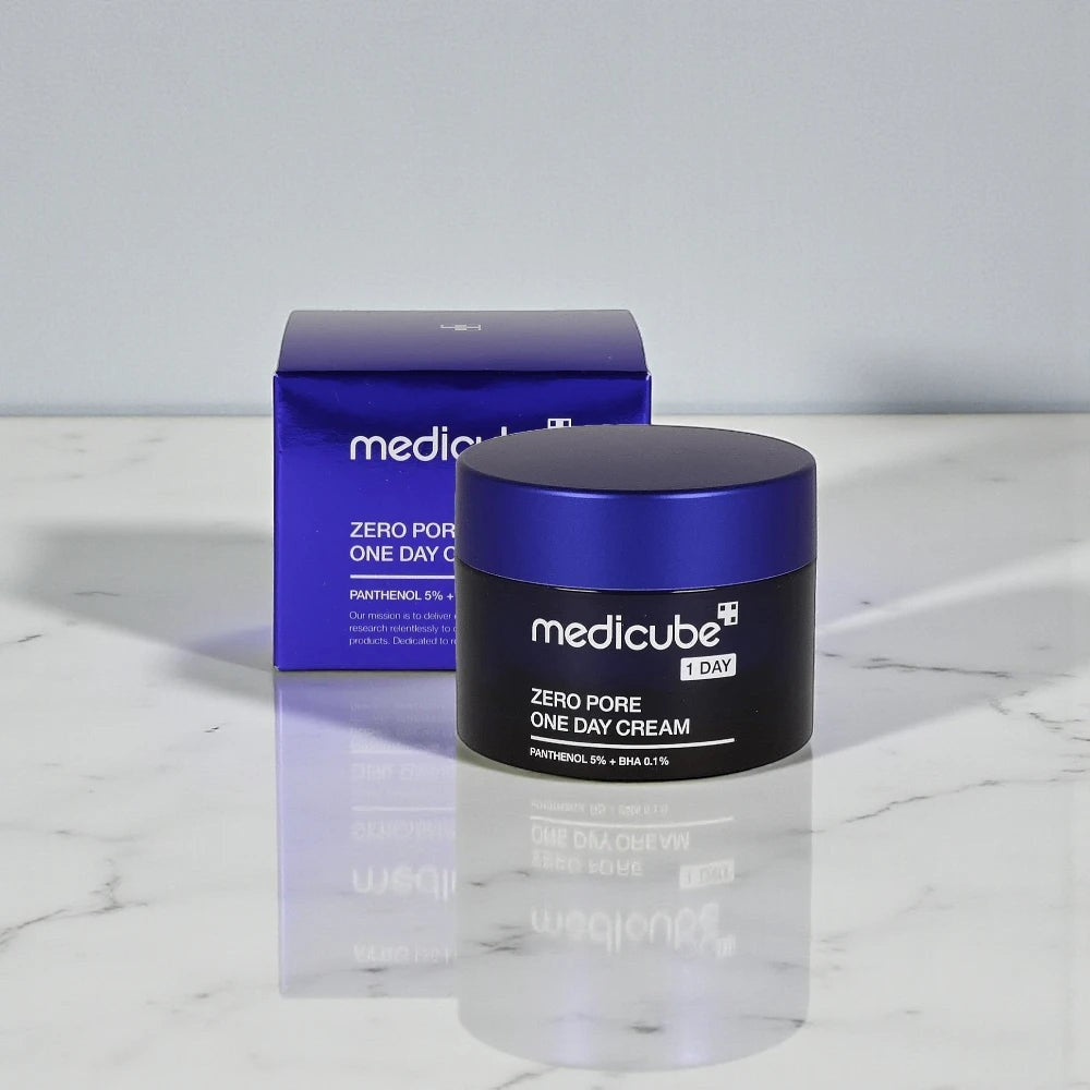 Skin TOGO Medicube Zero Pore One-day Cream in a black jar with a blue lid and matching product box on a marble surface.