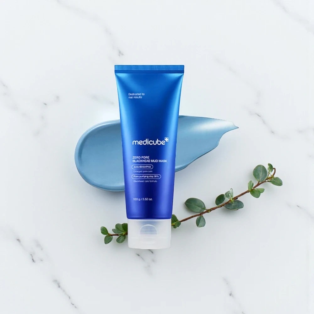 Skin TOGO Medicube Zero Pore Blackhead Mud Mask in a blue tube with a smear of clay on a white marble background.