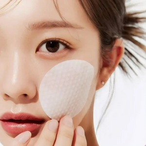 Skin TOGO Medicube Zero Pore Pad being applied to a woman's cheek for gentle exfoliation and pore refinement.