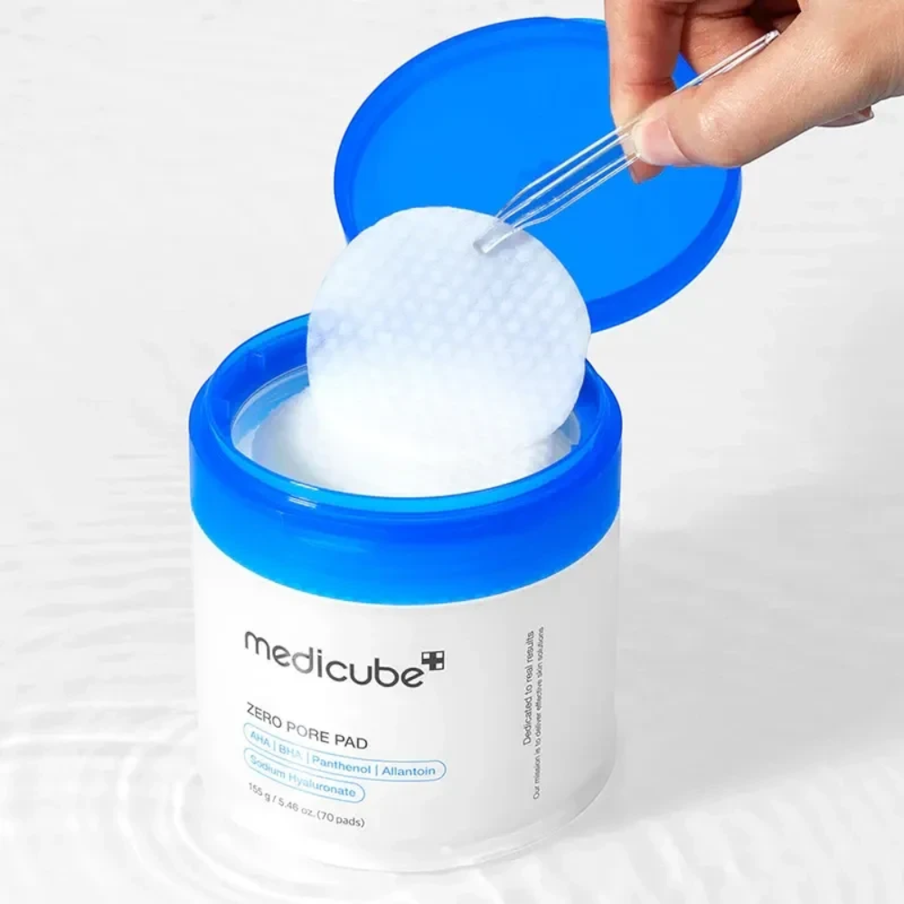 Skin TOGO Medicube Zero Pore Pad jar with a hand using tweezers to lift a textured exfoliating toner pad