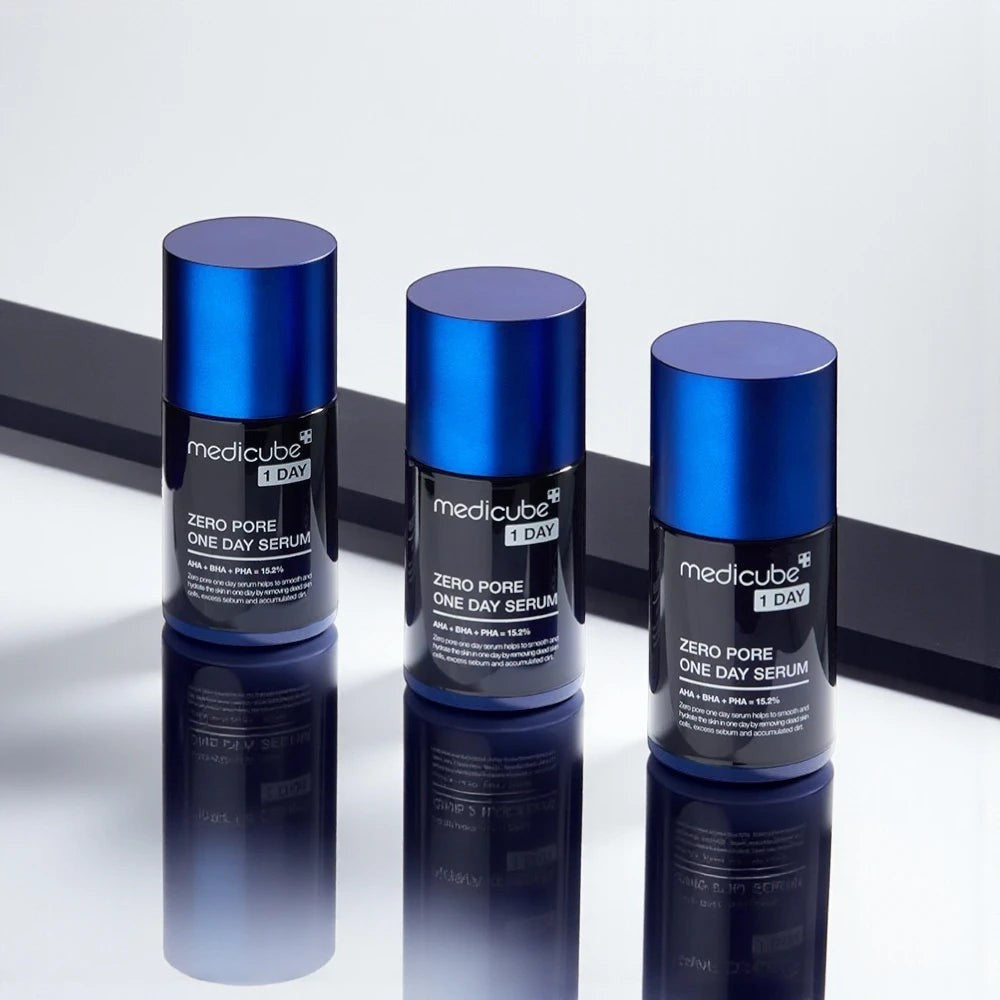 Skin TOGO Medicube Zero Pore One-day Serum bottles with blue caps and black labels on a reflective surface.