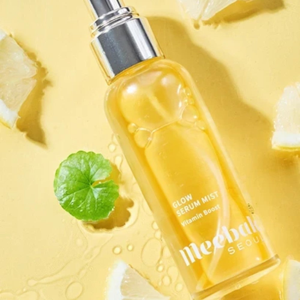 Skin TOGO Meebak Glow Serum Mist with Vitamin C, sea buckthorn, and niacinamide in a clear spray bottle on yellow