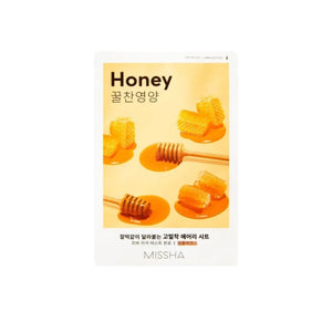 Skin TOGO Missha Airy Fit Honey sheet mask packaging featuring honeycombs and a wooden dipper on a white pedestal.