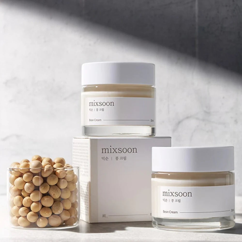 Skin TOGO Mixsoon Bean Cream jars with a glass of soybeans on a minimalist grey surface for deep hydration.