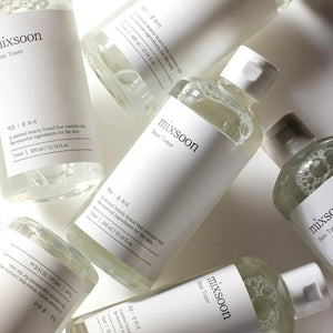 Skin TOGO Mixsoon Bifida Toner bottles arranged in a minimalist flat lay, showcasing the clear liquid skincare product.