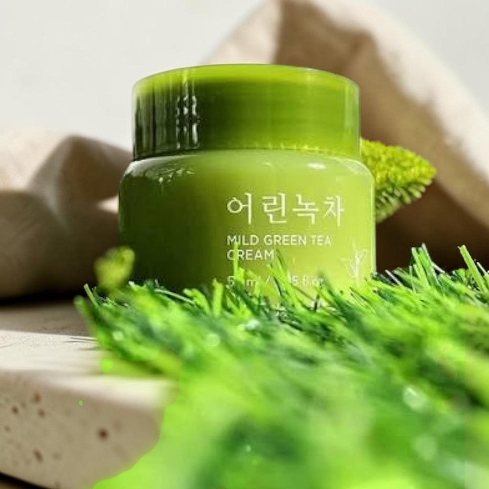 Skin TOGO NATURE REPUBLIC Young Green Tea Mild Cream in a green jar placed on fresh grass for a soothing skincare look.