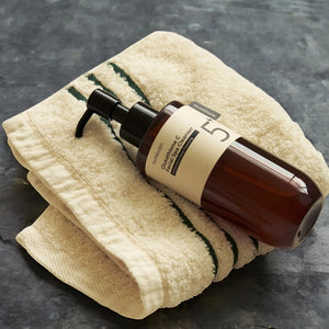 Skin TOGO Numbuzin No.5+ Glutathione Vitamin Facial Spa Cleanser bottle resting on a folded cream-colored towel.