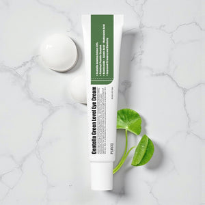 Skin TOGO Purito Centella Green Level eye cream tube with Centella Asiatica leaves on a white marble surface.