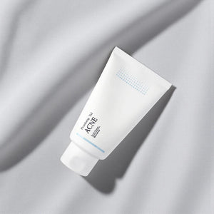 Skin TOGO Pyunkang Yul ACNE Facial Cleanser in a white 120ml squeeze tube on a soft grey fabric background.