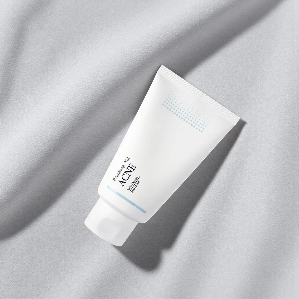 Skin TOGO Pyunkang Yul ACNE Facial Cleanser in a white 120ml squeeze tube on a soft grey fabric background.