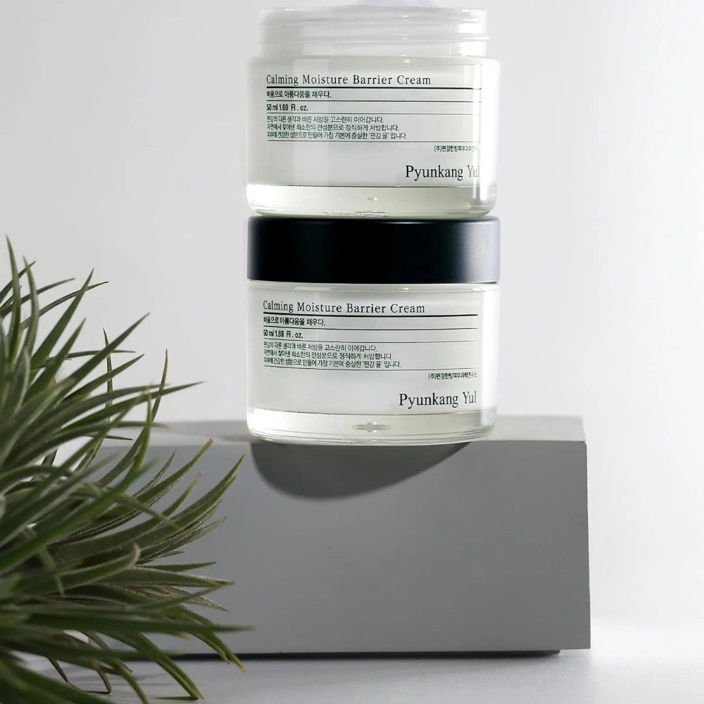 Skin TOGO Pyunkang Yul Calming Moisture Barrier Cream jars stacked on a grey pedestal with a small plant nearby.