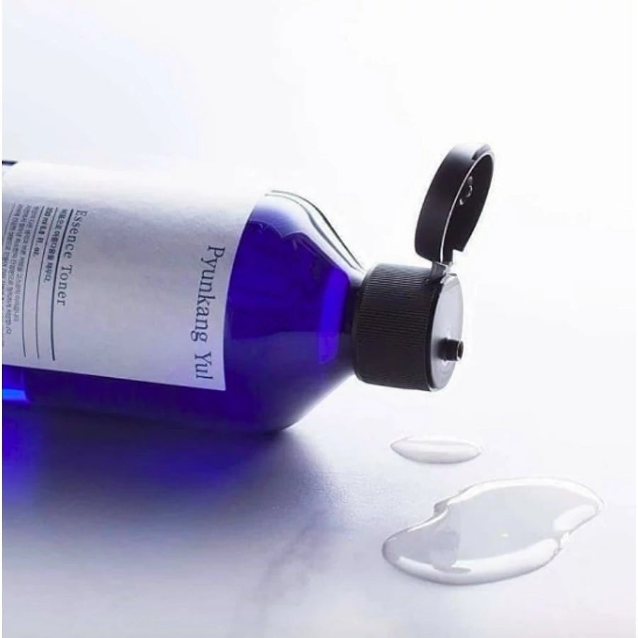 Skin TOGO Pyunkang Yul Essence Toner in a blue bottle with a flip-top cap, showing the clear liquid texture.