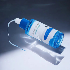 Skin TOGO Round Lab Birch Juice Moisturizing Ampoule in a blue translucent bottle with a dropper on a white surface.