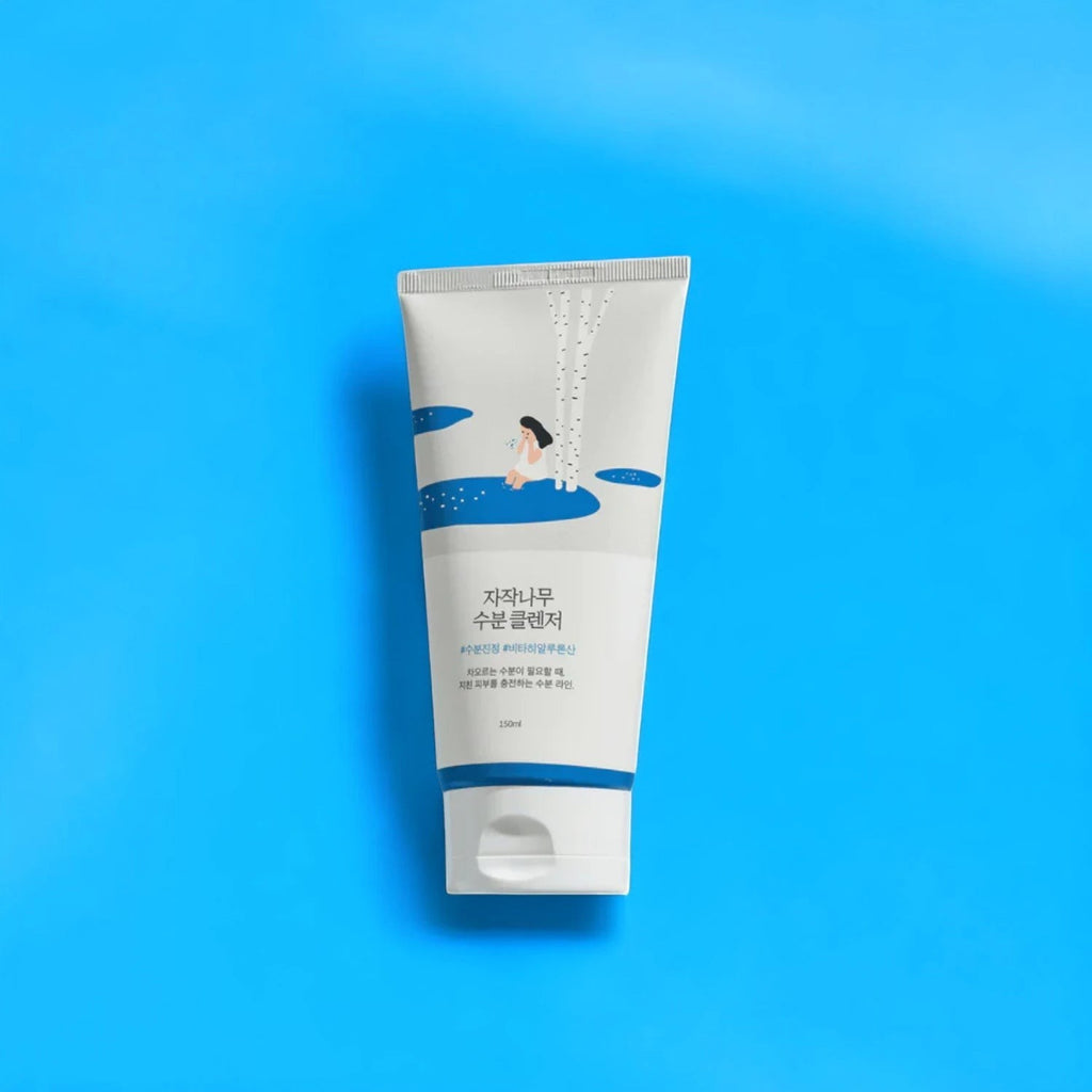 Skin TOGO Round Lab Birch Juice Moisturizing Cleanser in a white tube with blue accents on a bright blue background.