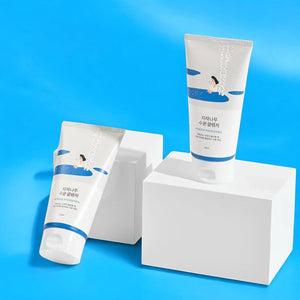 Skin TOGO Round Lab Birch Juice Moisturizing Cleanser tubes on white pedestals against a bright blue background