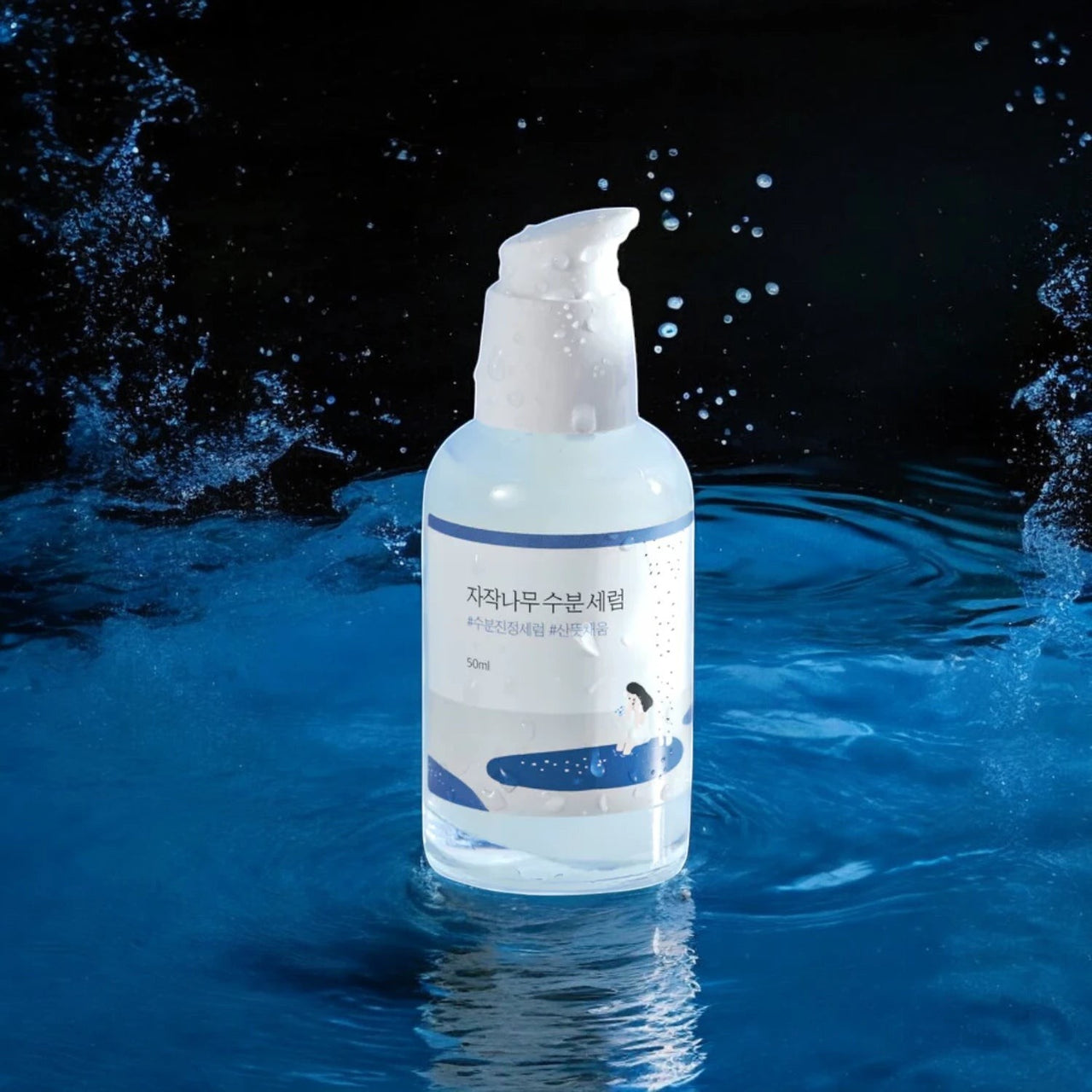 Skin TOGO Round Lab Birch Juice Moisturizing Serum bottle in water splash, highlighting deep hydration for dry skin.