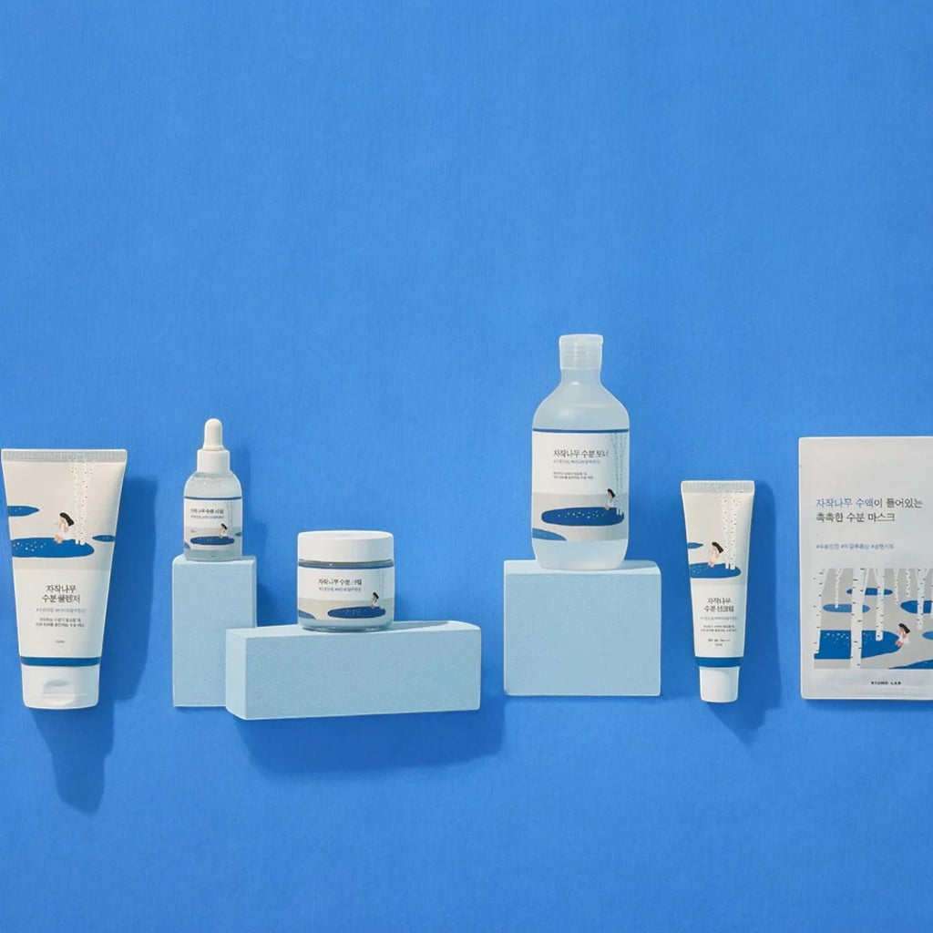 Skin TOGO Round Lab Birch Juice skincare collection featuring various moisturizing creams, serums, and masks on blue