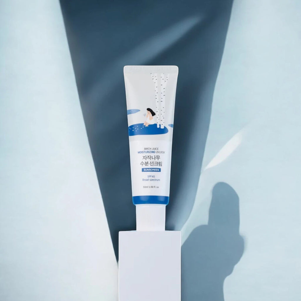 Skin TOGO Round Lab Birch Juice Moisturizing Sun Cream in a white tube with blue accents and birch tree illustration.