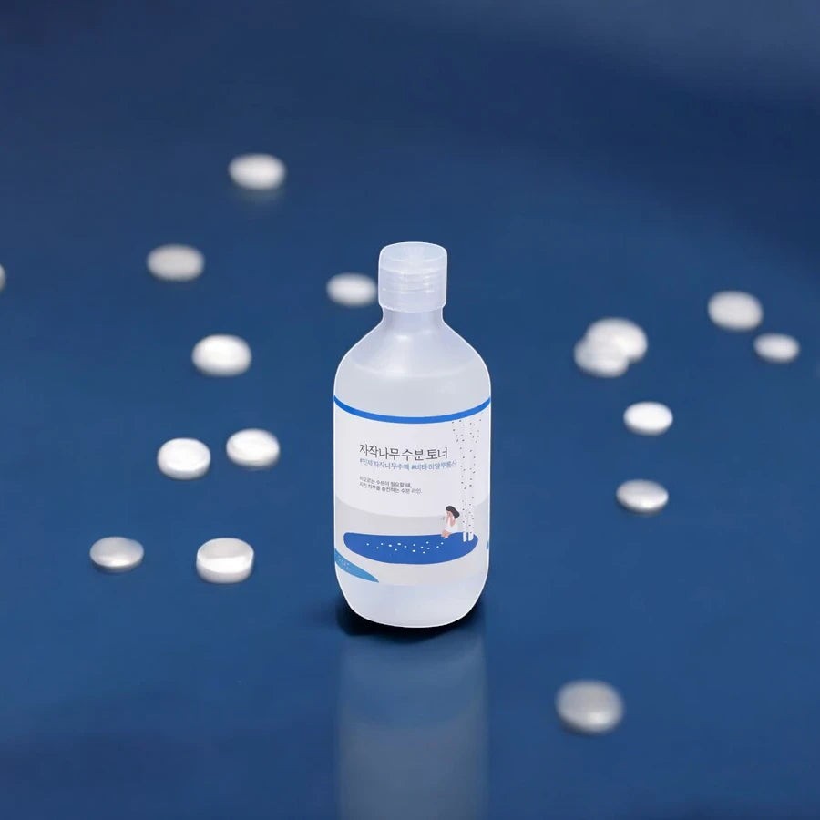 Skin TOGO Round Lab Birch Juice Moisturizing Toner in a clear 300ml bottle on a blue background with white accents.