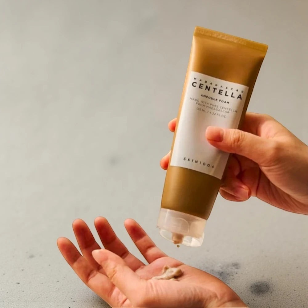 Skin TOGO SKIN1004 Madagascar Centella Ampoule Foam being dispensed from a brown tube into a hand