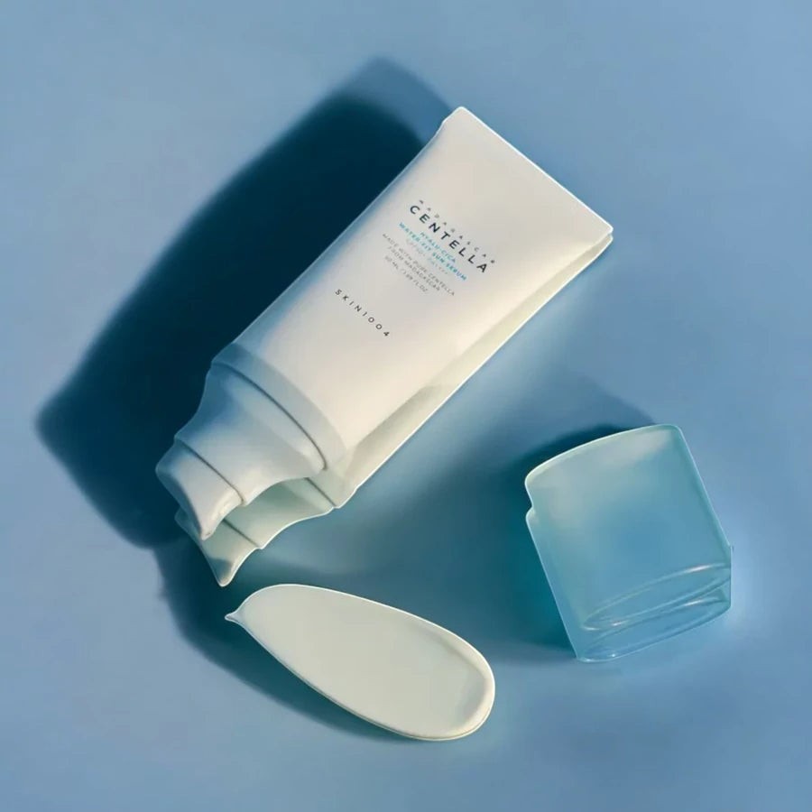 Skin TOGO SKIN1004 Madagascar Centella Hyalu-Cica Water-Fit Sun Serum tube with dispensed cream on blue background