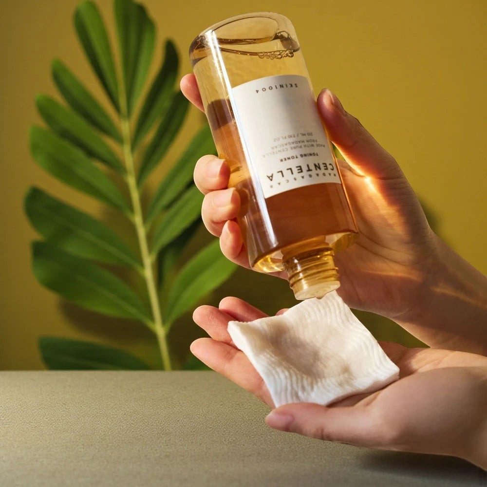Skin TOGO SKIN1004 Madagascar Centella Toning Toner being poured onto a cotton pad for gentle skincare application.