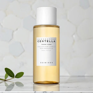 Skin TOGO SKIN1004 Madagascar Centella Toning Toner in a clear 400ml bottle with a white cap on a marble surface.
