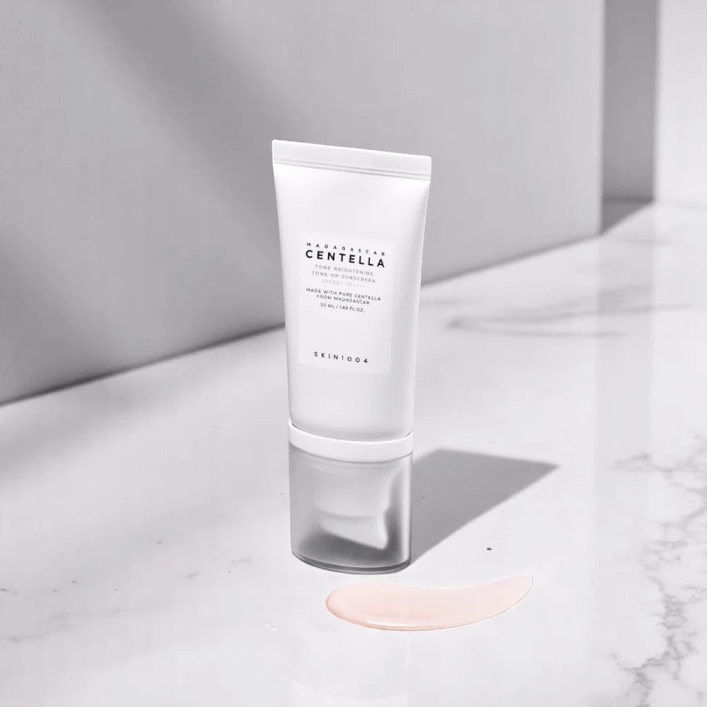 Skin TOGO SKIN1004 Madagascar Centella Tone Brightening Tone-Up Sunscreen SPF50+ tube with a drop of cream.