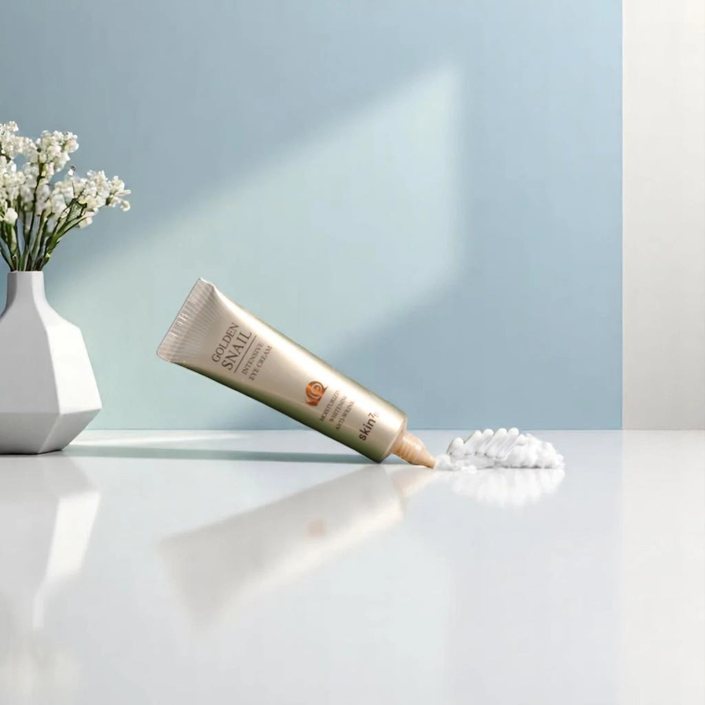 Skin TOGO Skin79 Golden Snail Intensive Eye Cream in a gold tube with a dollop of rich white cream on a white surface.