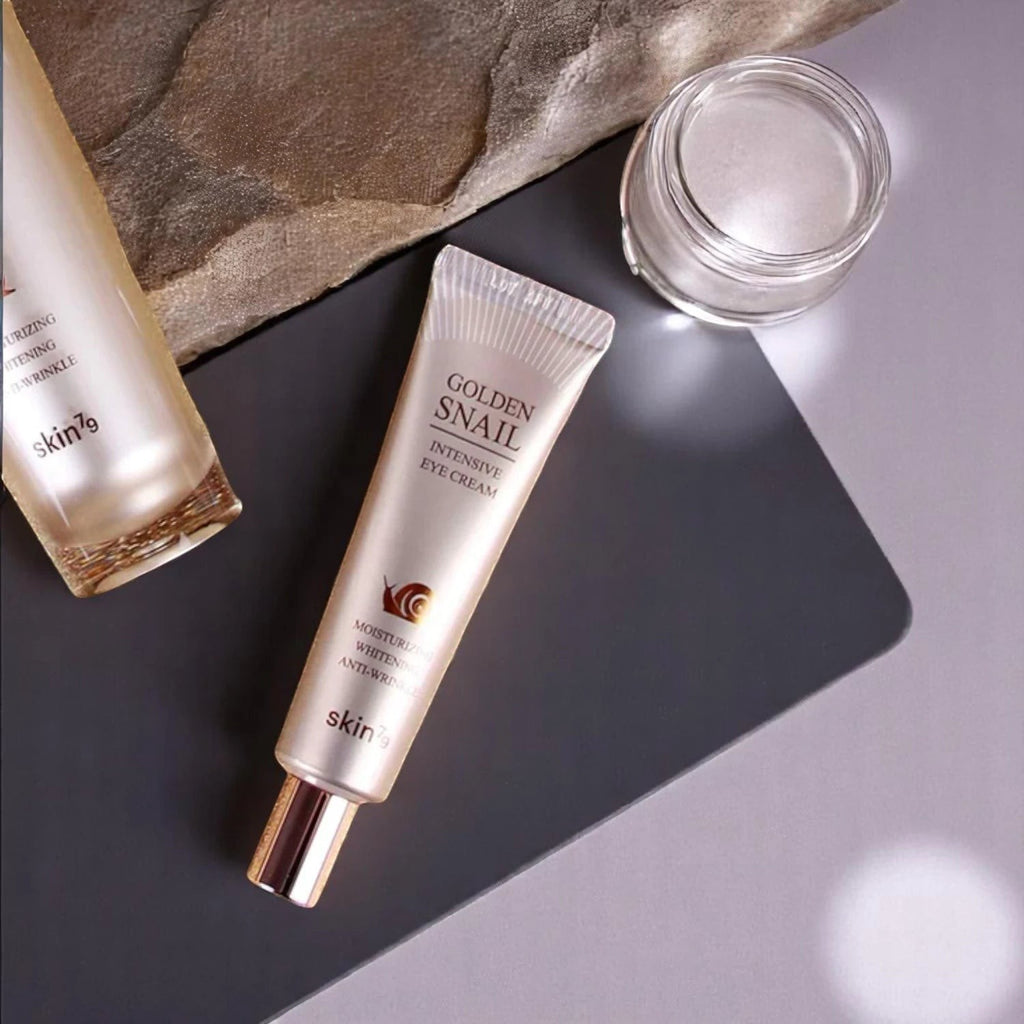 Skin TOGO Skin79 Golden Snail Intensive Eye Cream tube and jar on a grey surface with a stone accent.