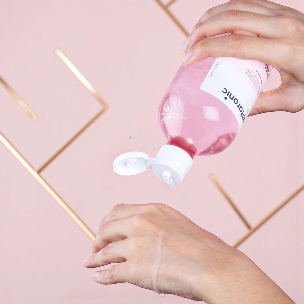 Skin TOGO SNP Prep Peptaronic serum being poured from a pink bottle onto a hand for hydration and anti-aging care.