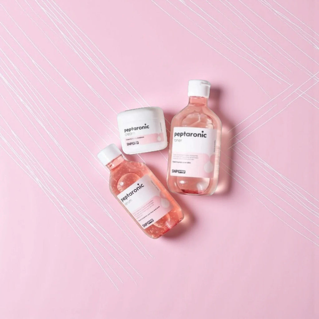 Skin TOGO SNP Prep Peptaronic skincare set including serum, toner, and cream in pink bottles on a pink background.
