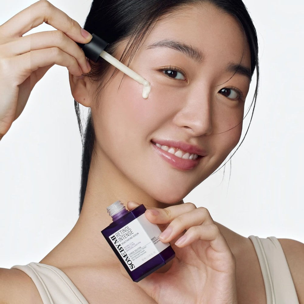 Skin TOGO model applying SOME BY MI Retinol Intense Reactivating Serum to her cheek with a dropper