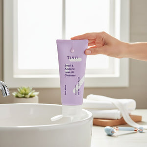 Skin TOGO TIAM Snail & Azulene Low pH Cleanser in a light purple tube held over a white bathroom sink.